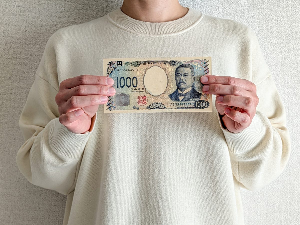 北里柴三郎の千円札を両手で持つ人