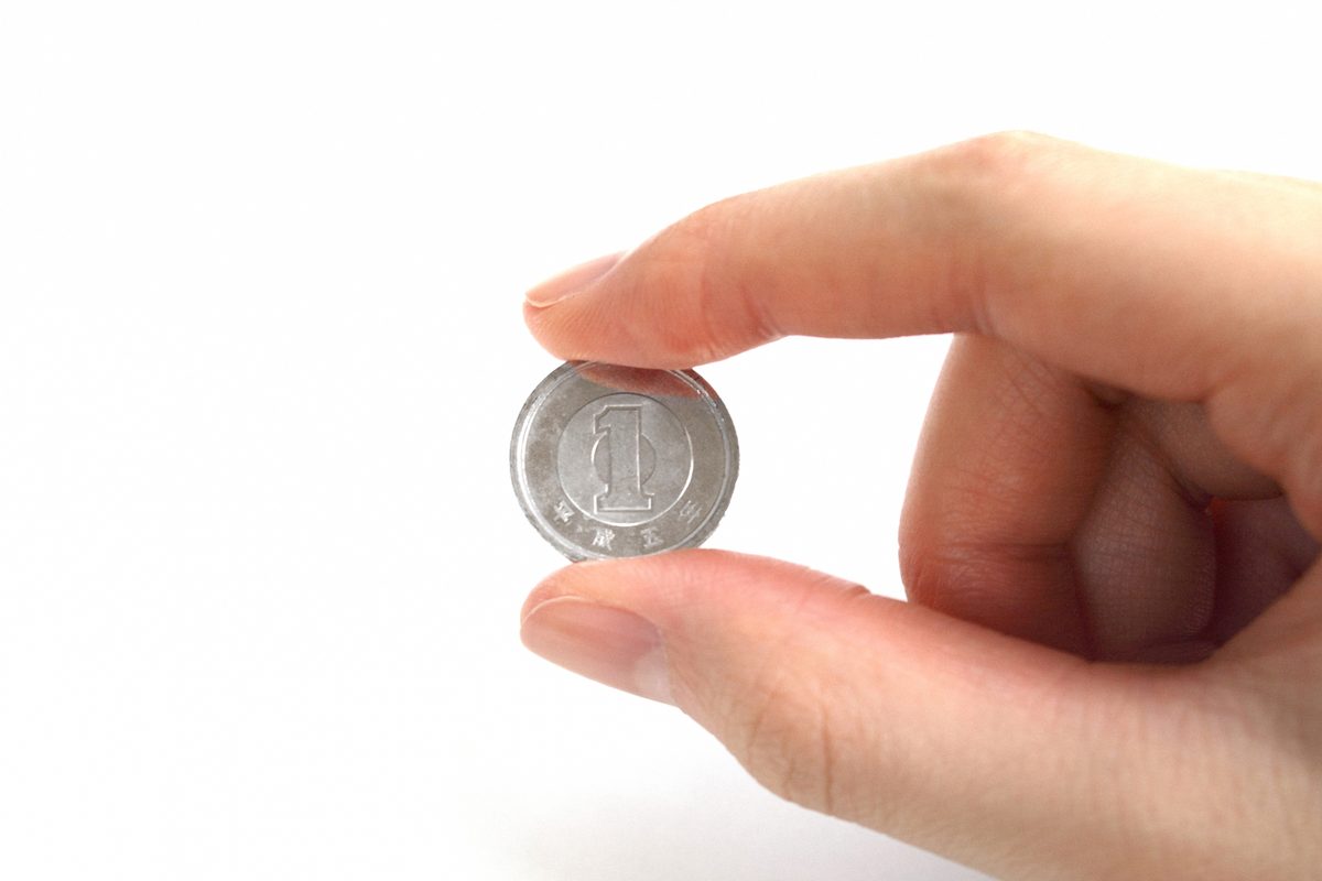1円玉を指でつまんで持つ手