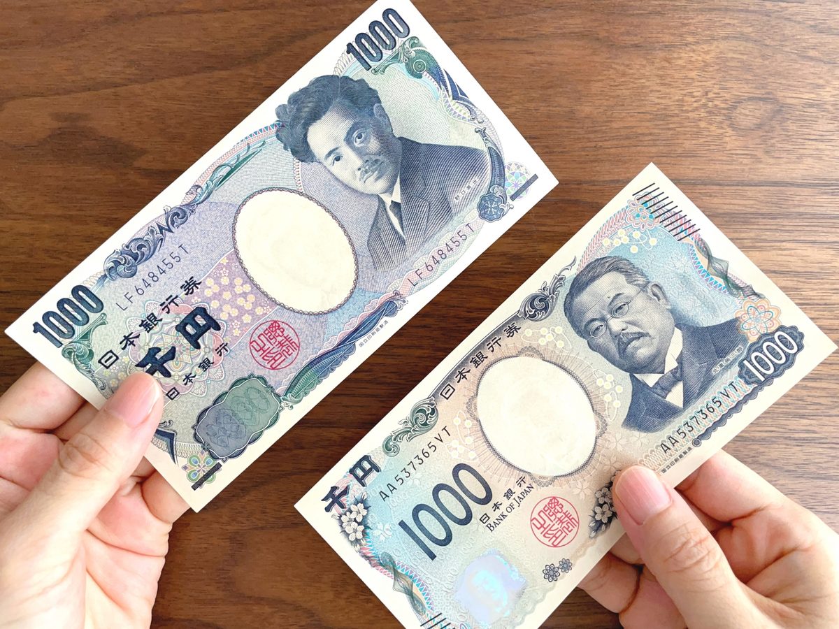 野口英世の千円札と北里柴三郎の千円札を並べて持つ手